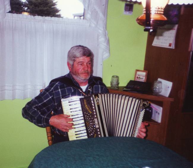 Jack at friends house playing friends accordian, March 2000